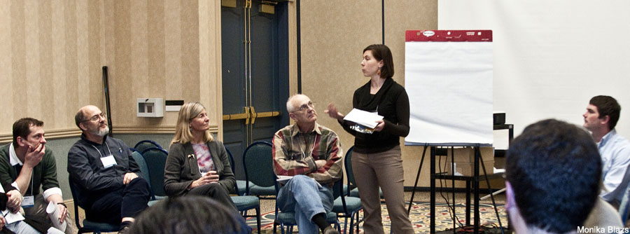 Woman standing and speaking to group of people