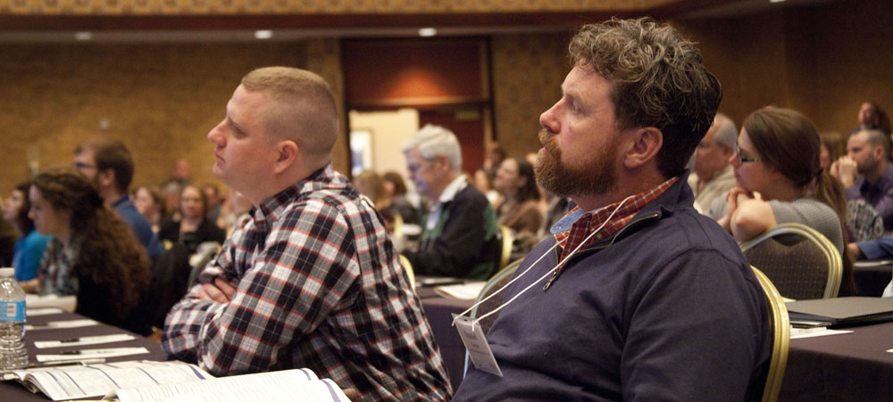 Two men sitting and listening