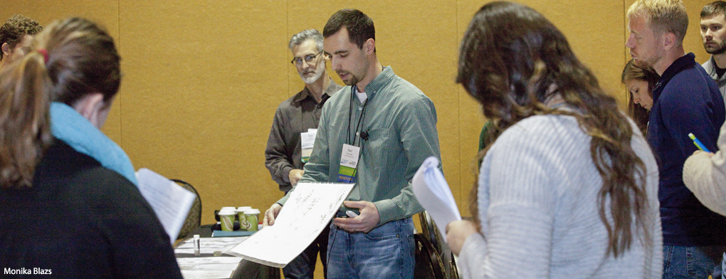 Paul Skawinski, holding up a diagram to a group of people, leads an Aquatic Macrophytes workshop.