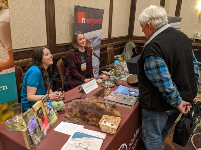 a conference attendee speaks with exhibitors